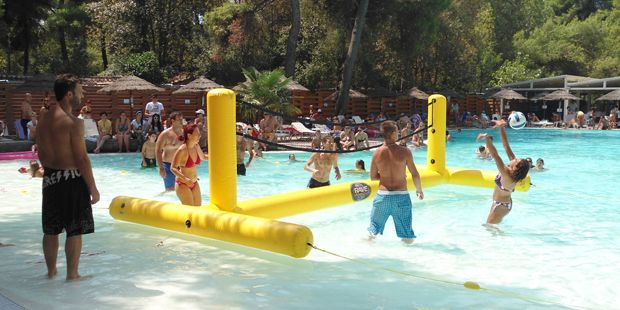 Adults playing pool volleyball